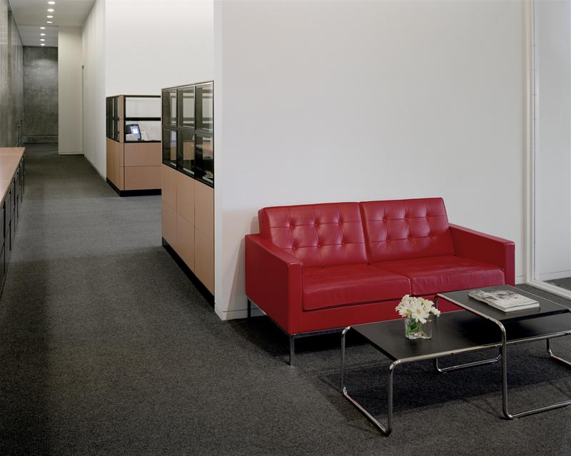 Laccio Couchtisch klein von Knoll International, schwarze Tischplatte mit Blumen und rotes Sofa.