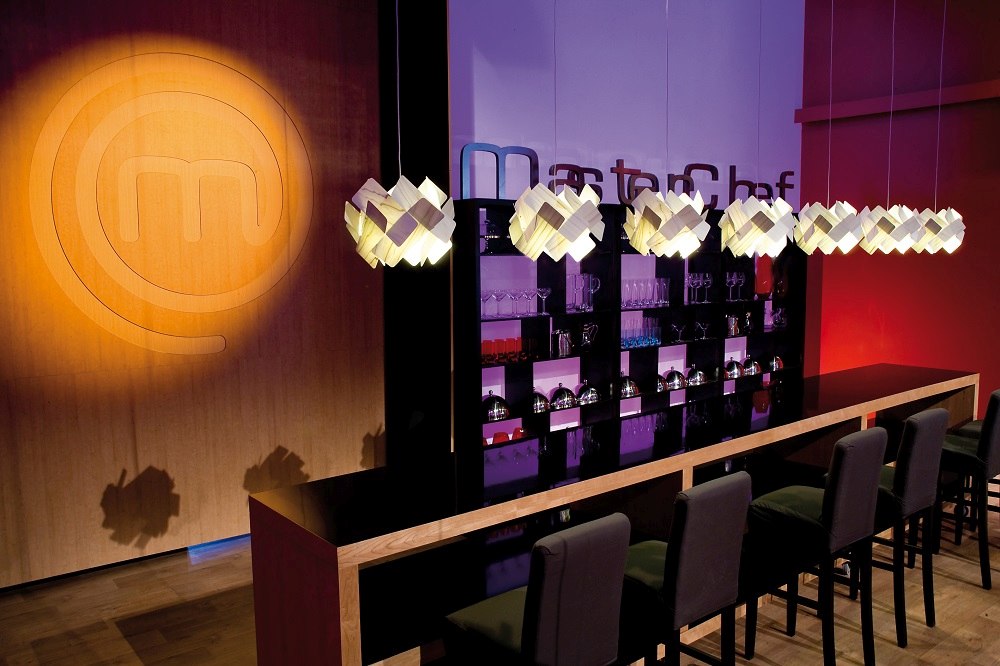 Reihe von Escape Pendelleuchten von LZF Lamps über einer Bar mit Stühlen.