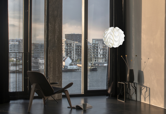 Weiße Le Klint Pendelleuchte Model 172 Medium im modernen Wohnraum mit Fensterblick.