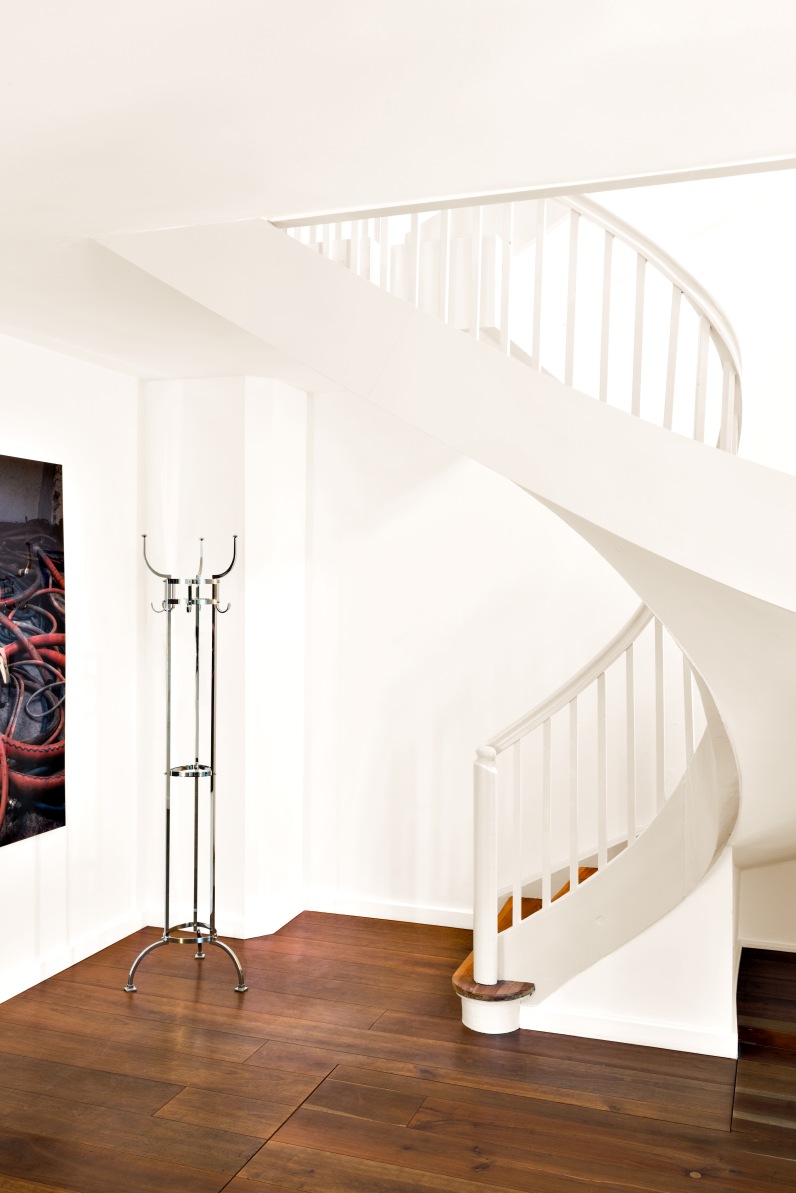 Nymphenburg Garderobenständer ClassiCon aus Nickel im Flur mit Holzfußboden und Wendeltreppe.