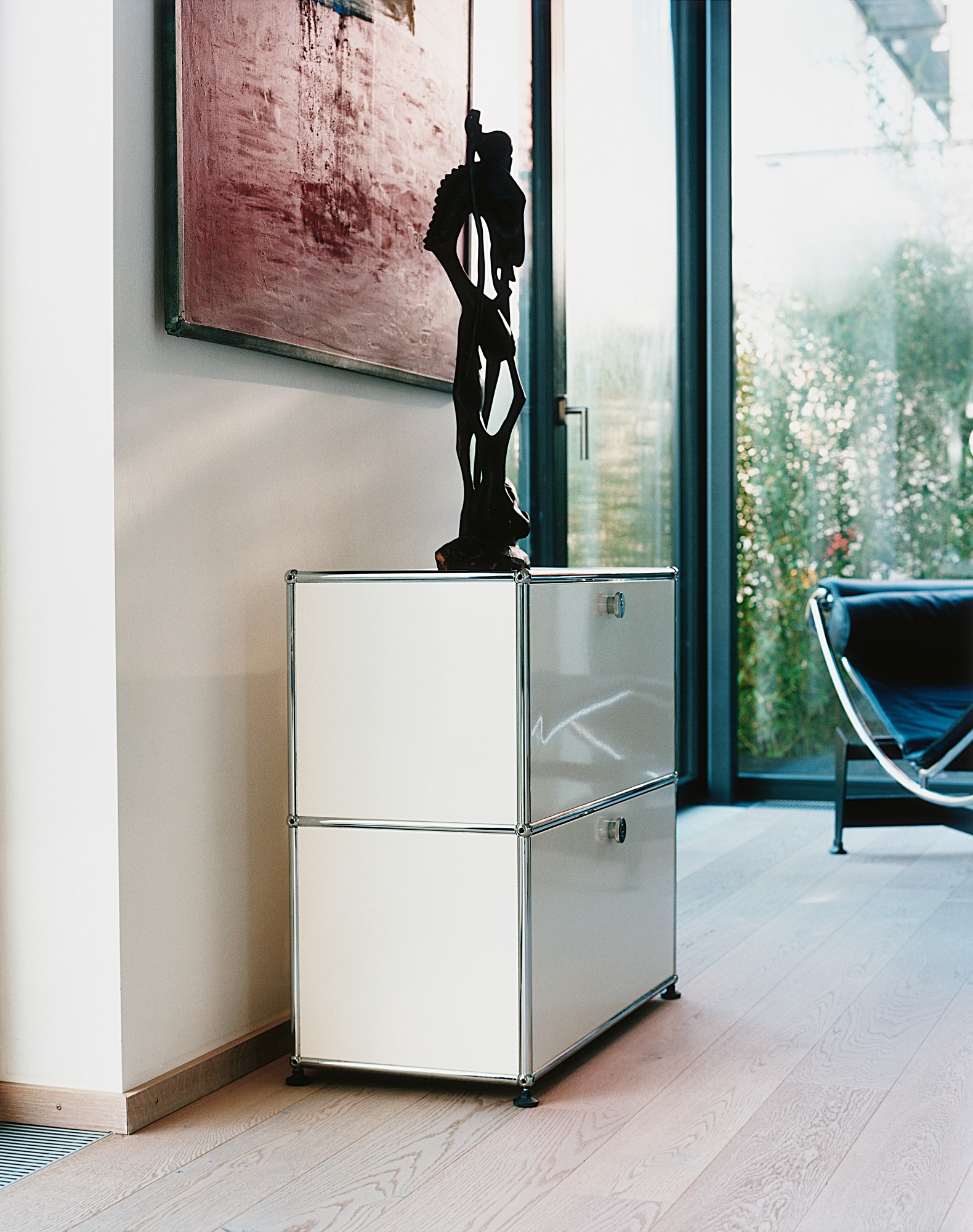 Kleines, weißes USM Haller Sideboard mit zwei Fächern im modernen Wohnzimmer.
