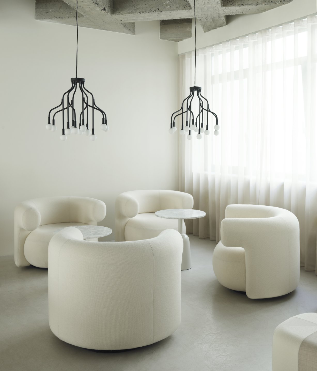 Innenaufnahme: Wohnzimmer mit Sesseln und Turn Table Marmor Tisch von Normann Copenhagen mit Marmorplatte.