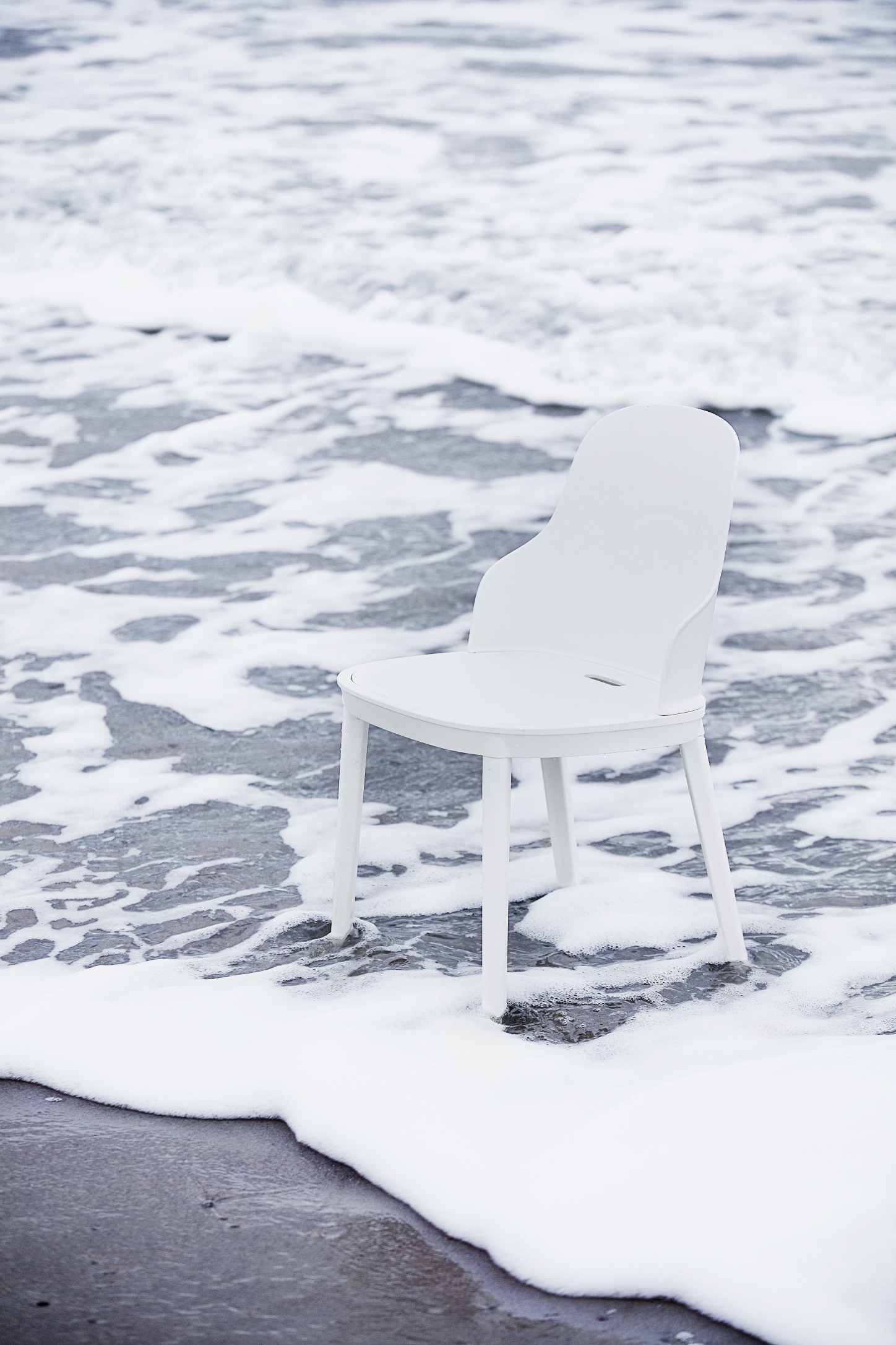 Weißer Allez Chair Stuhl von Normann Copenhagen am Strand im Meerwasser. Designstuhl.