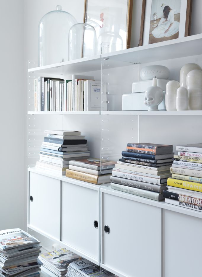 Regalböden des String Regalsystems in Weiß, bestückt mit Büchern und Deko-Objekten.