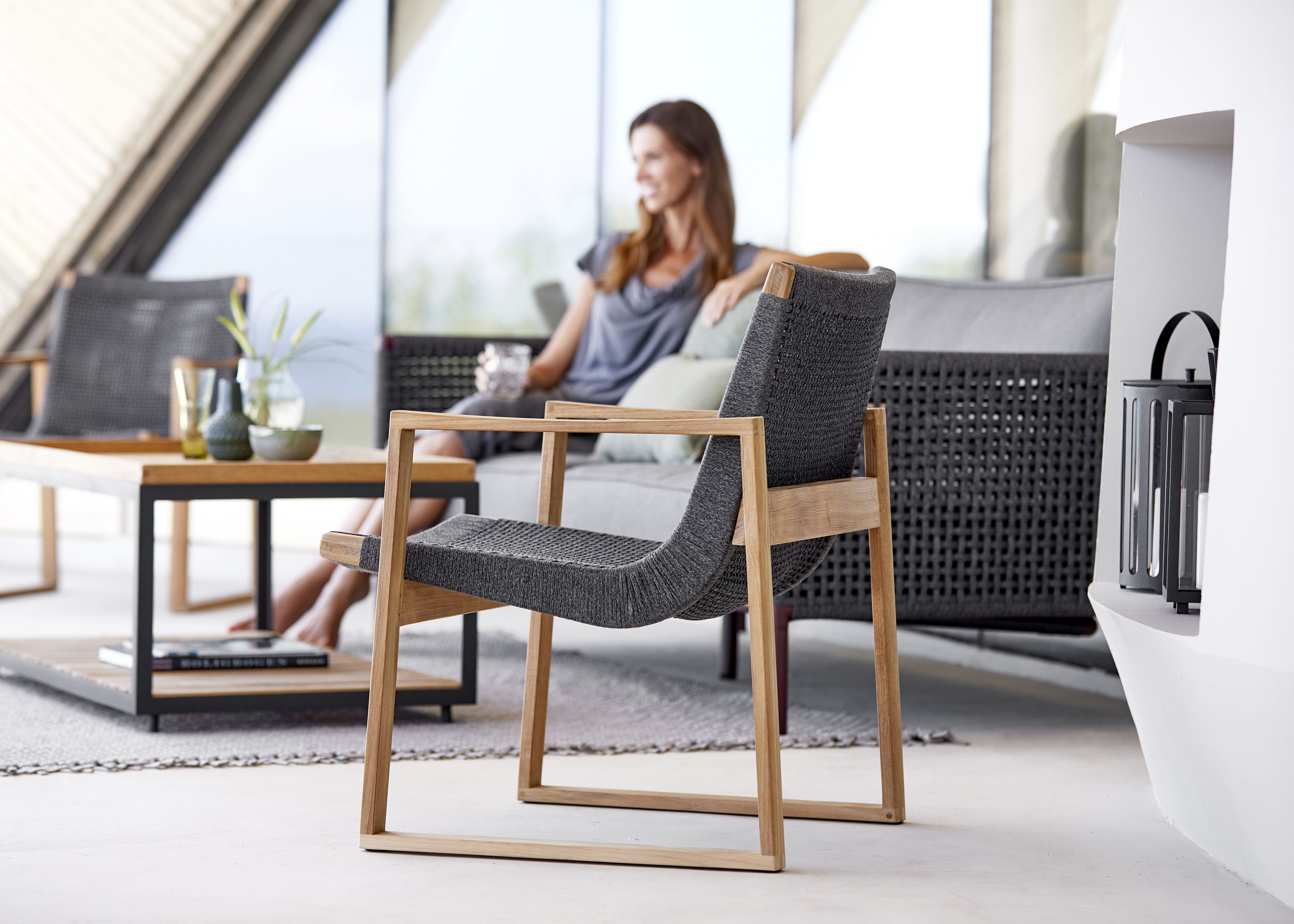 Endless Loungesessel von Cane-Line mit grauem Geflecht und hellem Holzgestell für den Garten.