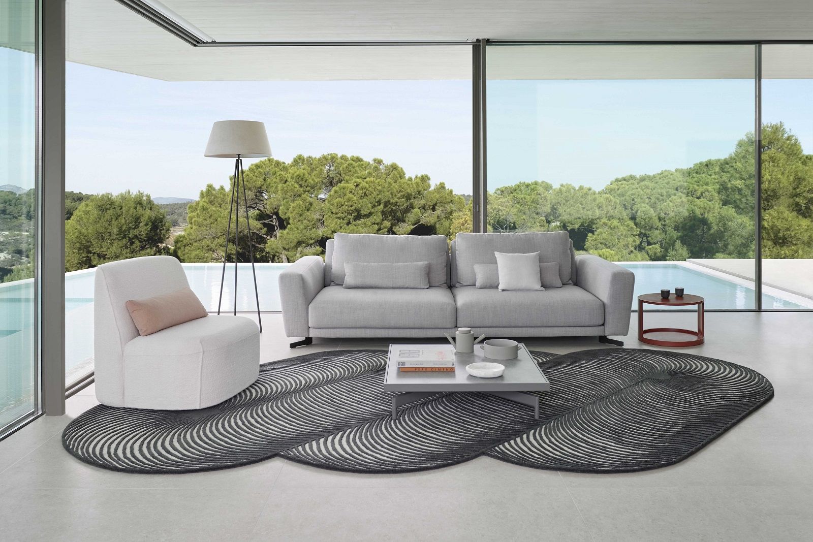 Wohnzimmer mit grauem Sofa und Giro Teppich von Gan mit abstraktem Muster.