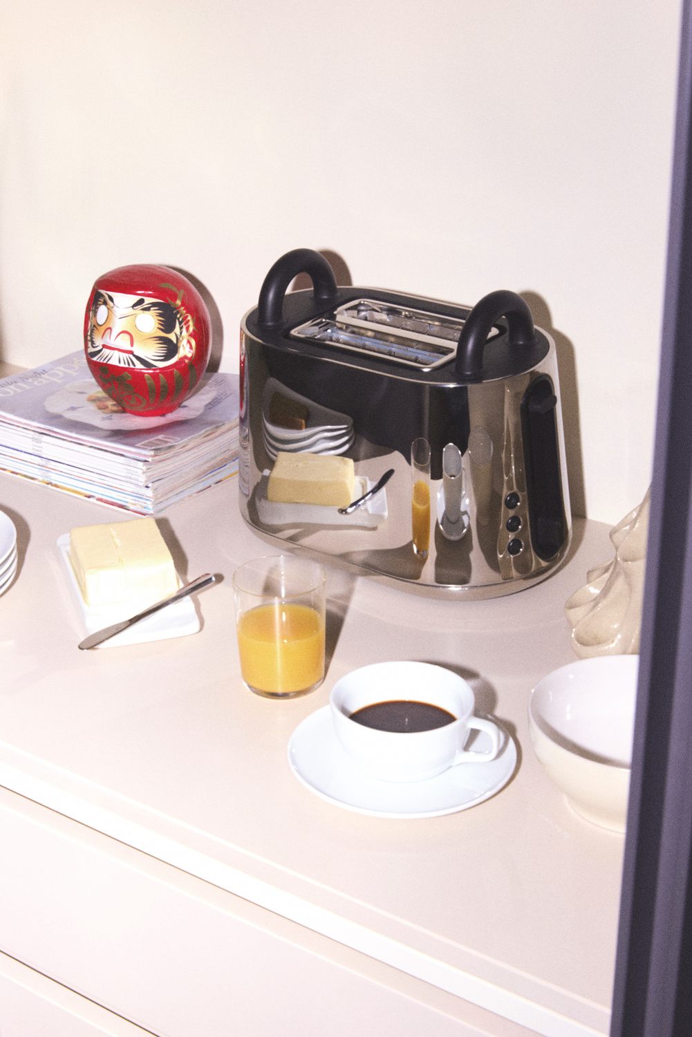 NE03 B Toru Toaster von Alessi auf einem Frühstückstisch mit Kaffee, Saft und Butter.