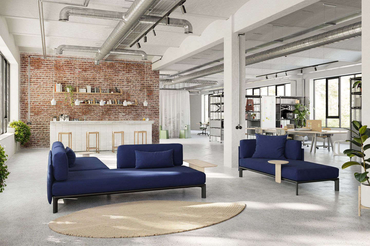 Blauer Vitra Anagram Plattformverbinder im modernen Büro-Loft. Modulares Sofa-System für flexible Raumlösungen.