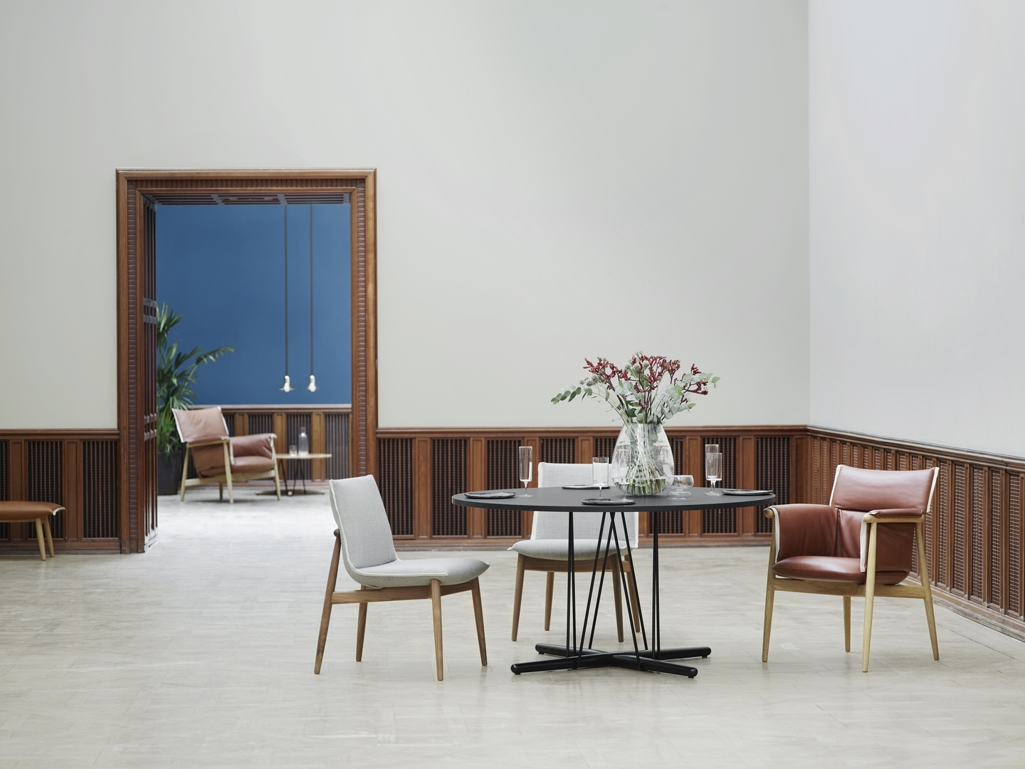 E020 Embrace Tisch von Carl Hansen & Søn mit Stühlen in einem stilvollen Raum.