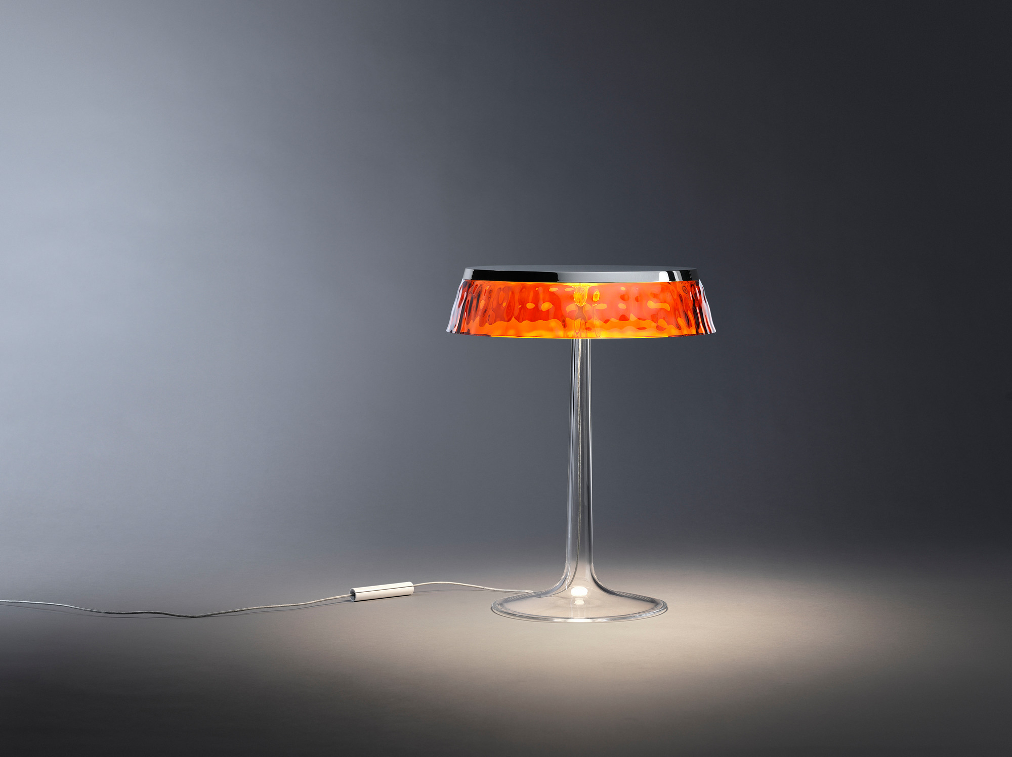 Bon Jour Tischleuchte von Flos: Moderne Tischlampe mit transparentem Fuß und orangefarbenem Lampenschirm.