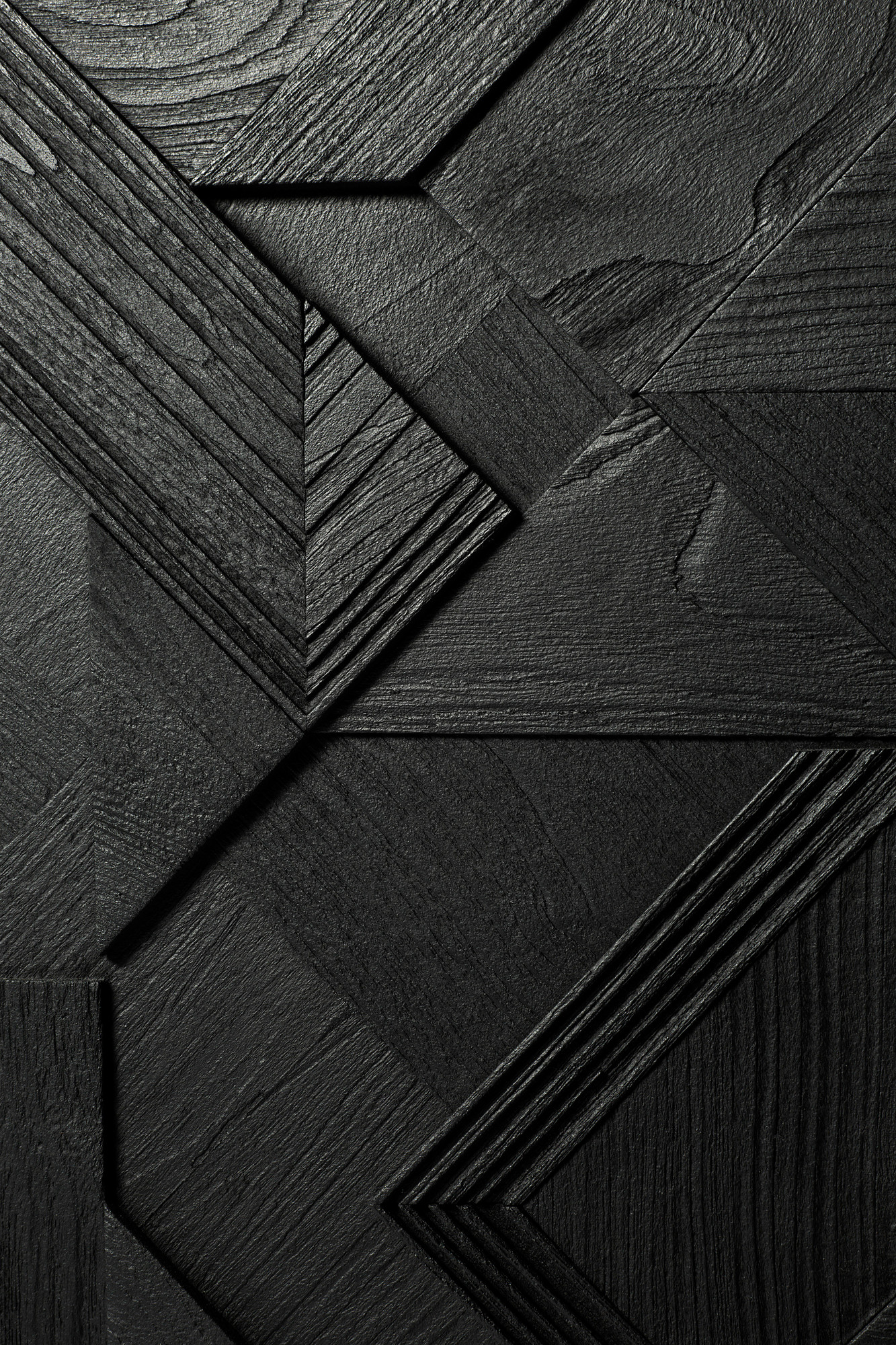 Detailaufnahme der schwarzen Teakholz-Oberfläche der Graphic Anrichte von Ethnicraft mit geometrischen Mustern.