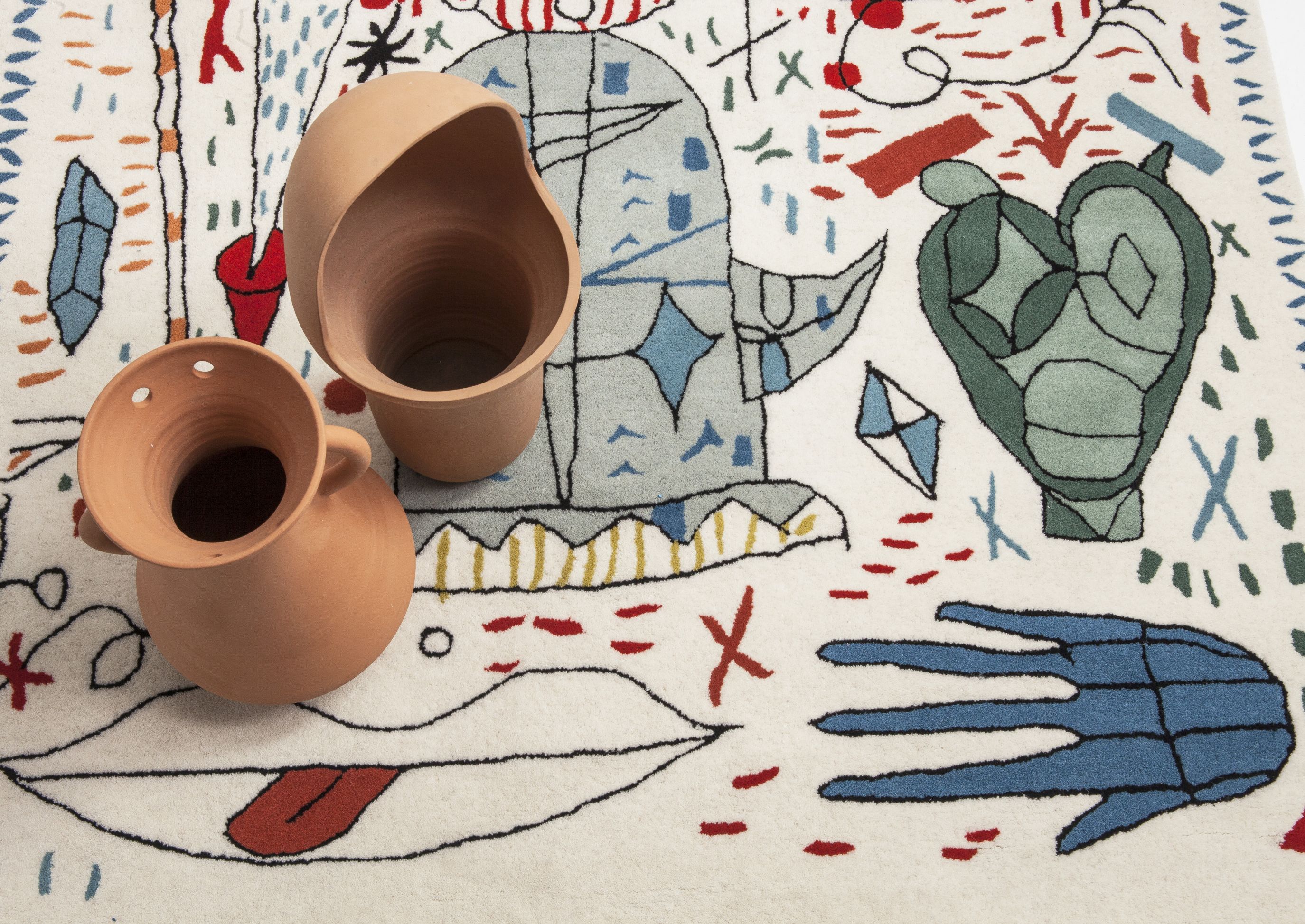 Hayon x Nani Teppich mit abstrakten Motiven und zwei Terrakotta-Vasen im Vordergrund.
