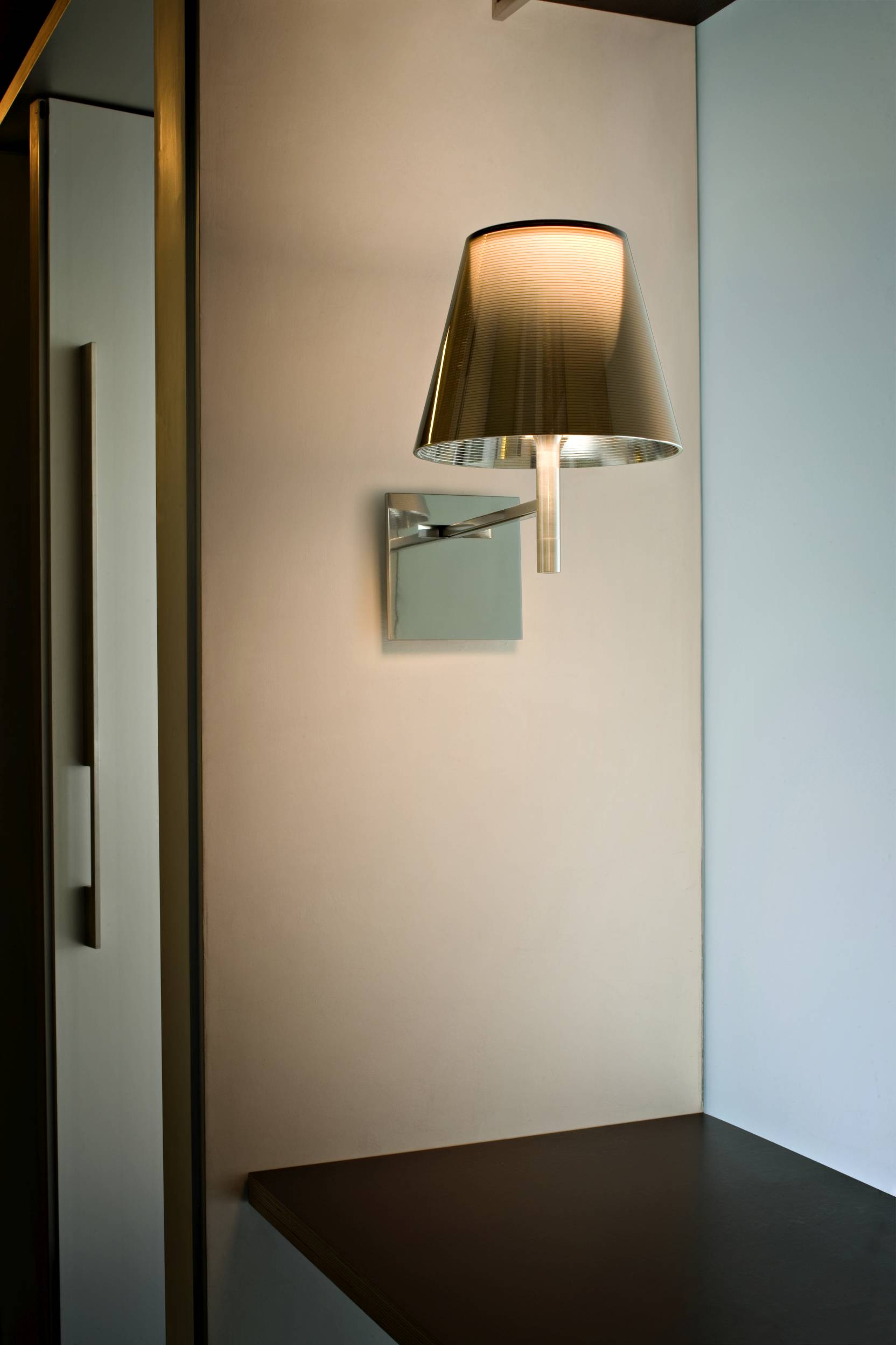 Ktribe Wandleuchte von Flos, modernes Design mit grauem Lampenschirm und warmem Licht.