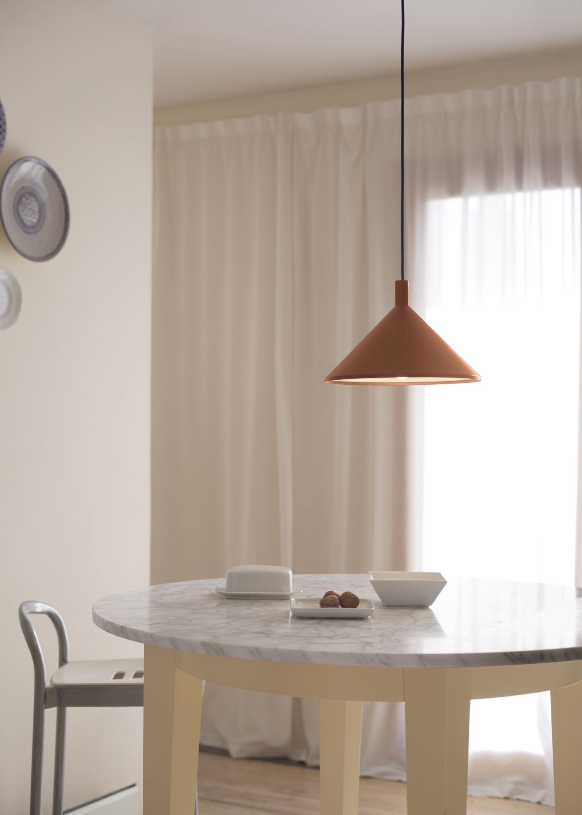 Cono Hängeleuchte von Martinelli Luce über Esstisch mit Marmorplatte. Moderne Pendelleuchte in Terrakotta.