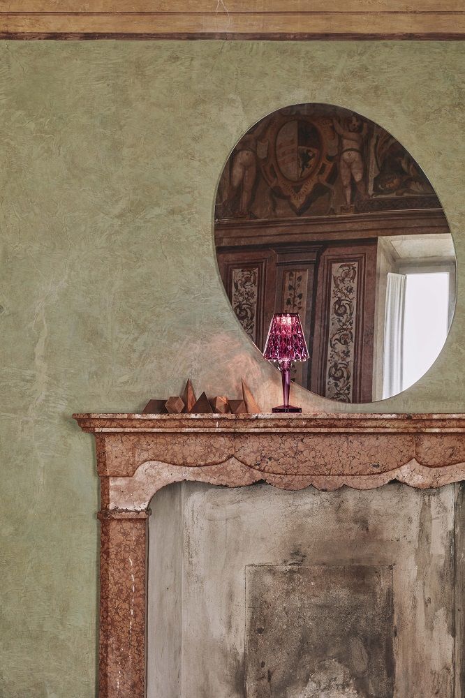 Nahaufnahme: Big Battery Tischleuchte von Kartell, Cola-Farbe, Akku-betriebene Lampe auf Kaminsims.