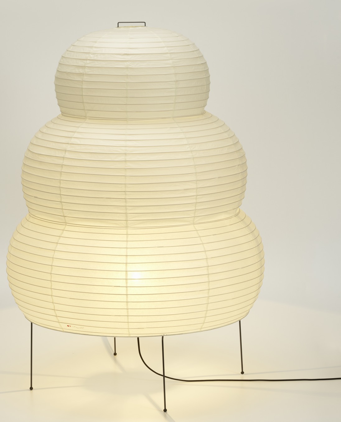 Akari Stehleuchte 25N von Vitra: Dreistufige Papierleuchte auf filigranem Metallgestell, warmes Licht.