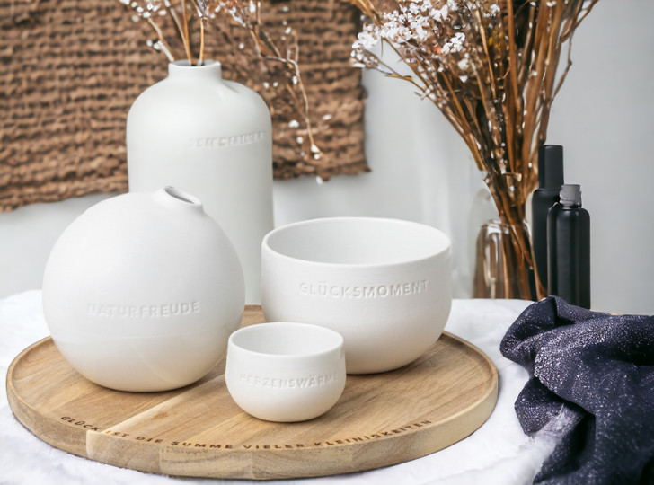 Tablett der kleinen Dinge von Räder mit weißen Keramikvasen und Schalen mit inspirierenden Botschaften.