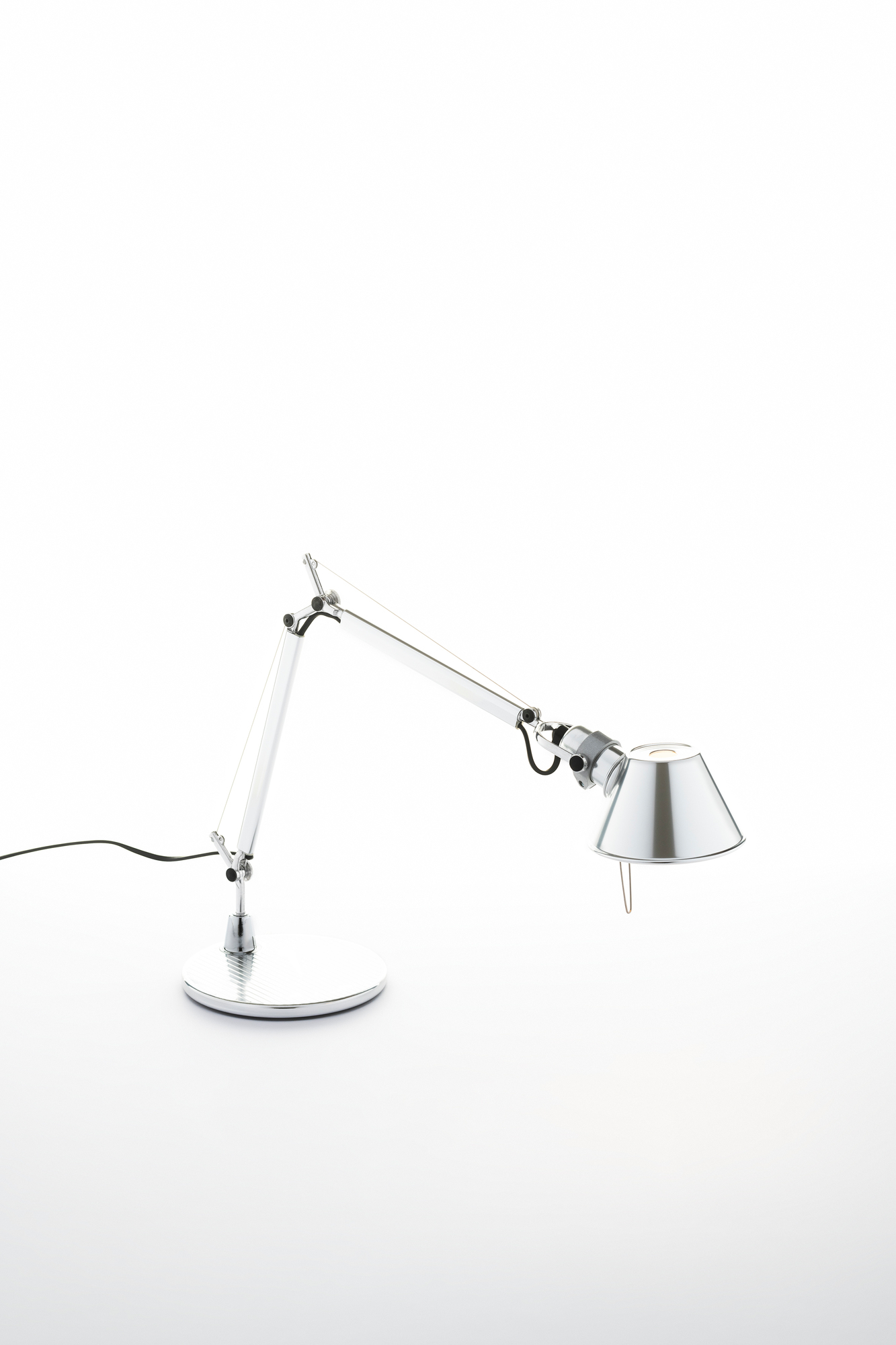 Nahaufnahme der Artemide Tolomeo Micro Tischleuchte in poliertem Chrom mit rundem Fuß.