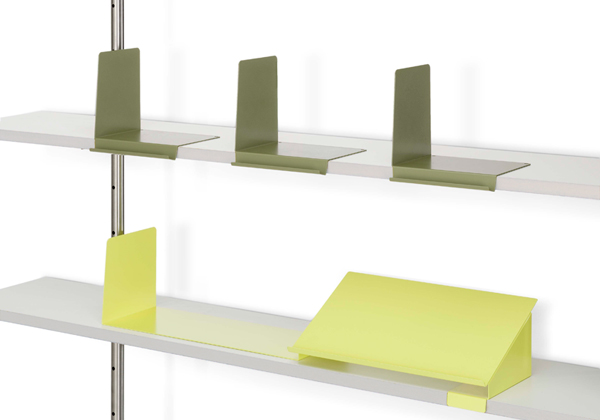 Buchstützen für Eiermann Regal von Richard Lampert in Grün und Gelb auf weißen Regalböden.