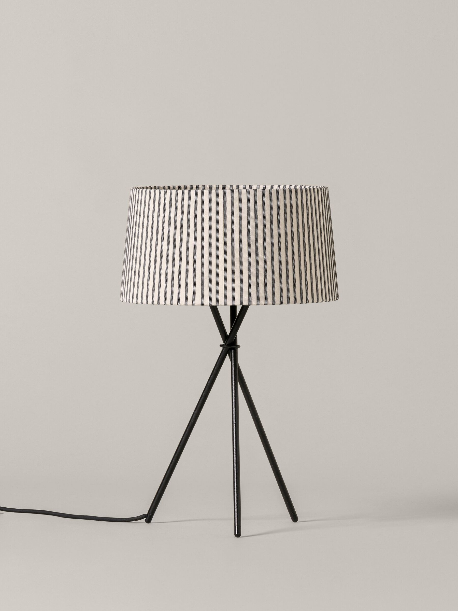 Tripode M3 Tischleuchte mit Bretona Stripes Schirm von Santa & Cole auf schwarzem Stativfuß.