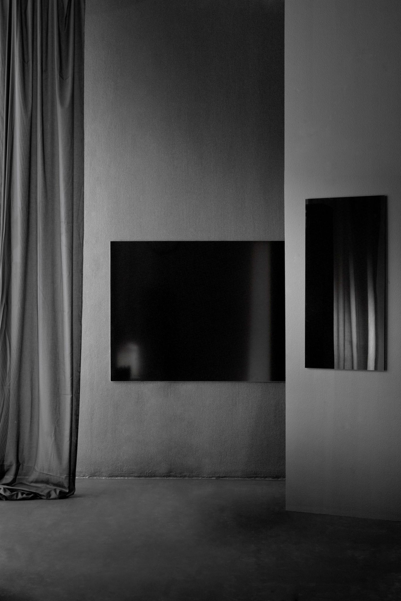 Schwarze, magnetische Chat Board Wand Glastafel, rechteckig und hochkant, an grauer Wand befestigt. Moderne Büroeinrichtung.