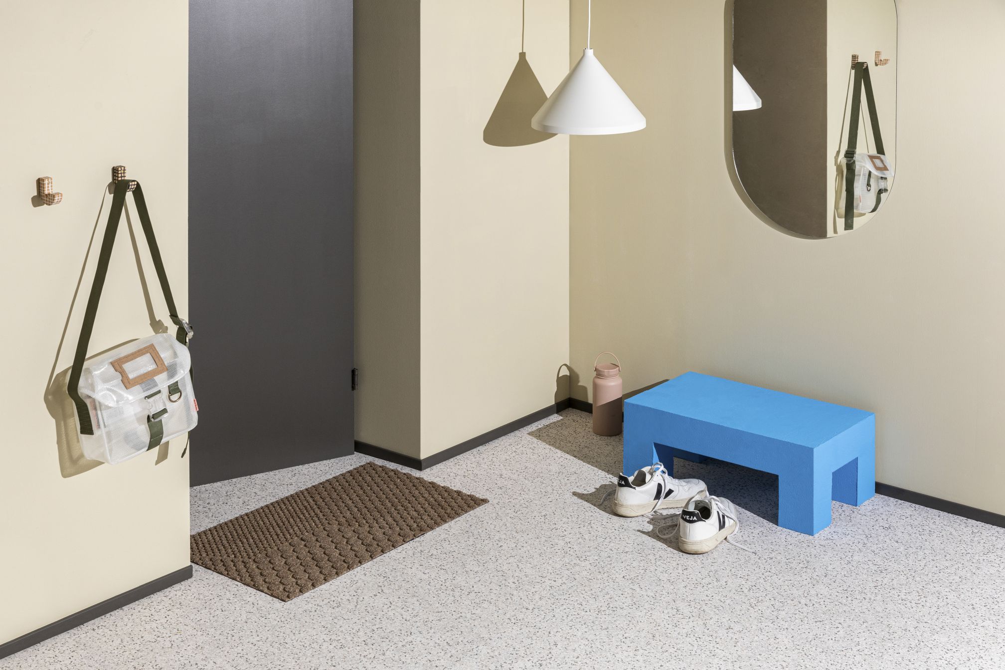 Braune Heymat Fußmatte "Desert" vor einer Tür, im Flur mit Bank und Dekoration.