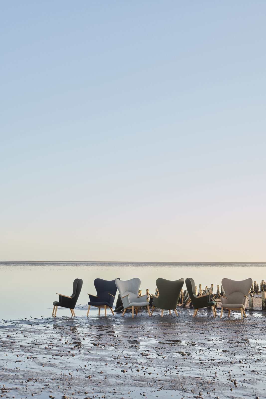CH78 Mama Bear Sessel von Carl Hansen & Søn in verschiedenen Farben am Strand.
