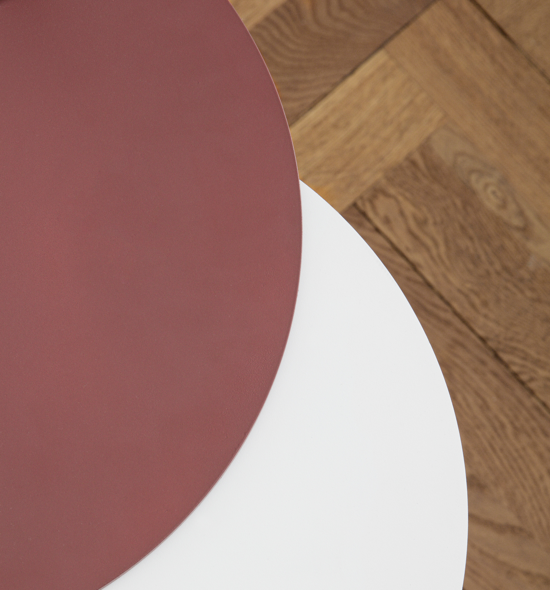 Detailaufnahme: Normann Copenhagen Stock Table Beistelltisch, runde Tischplatten in Weiß und Rotbraun.