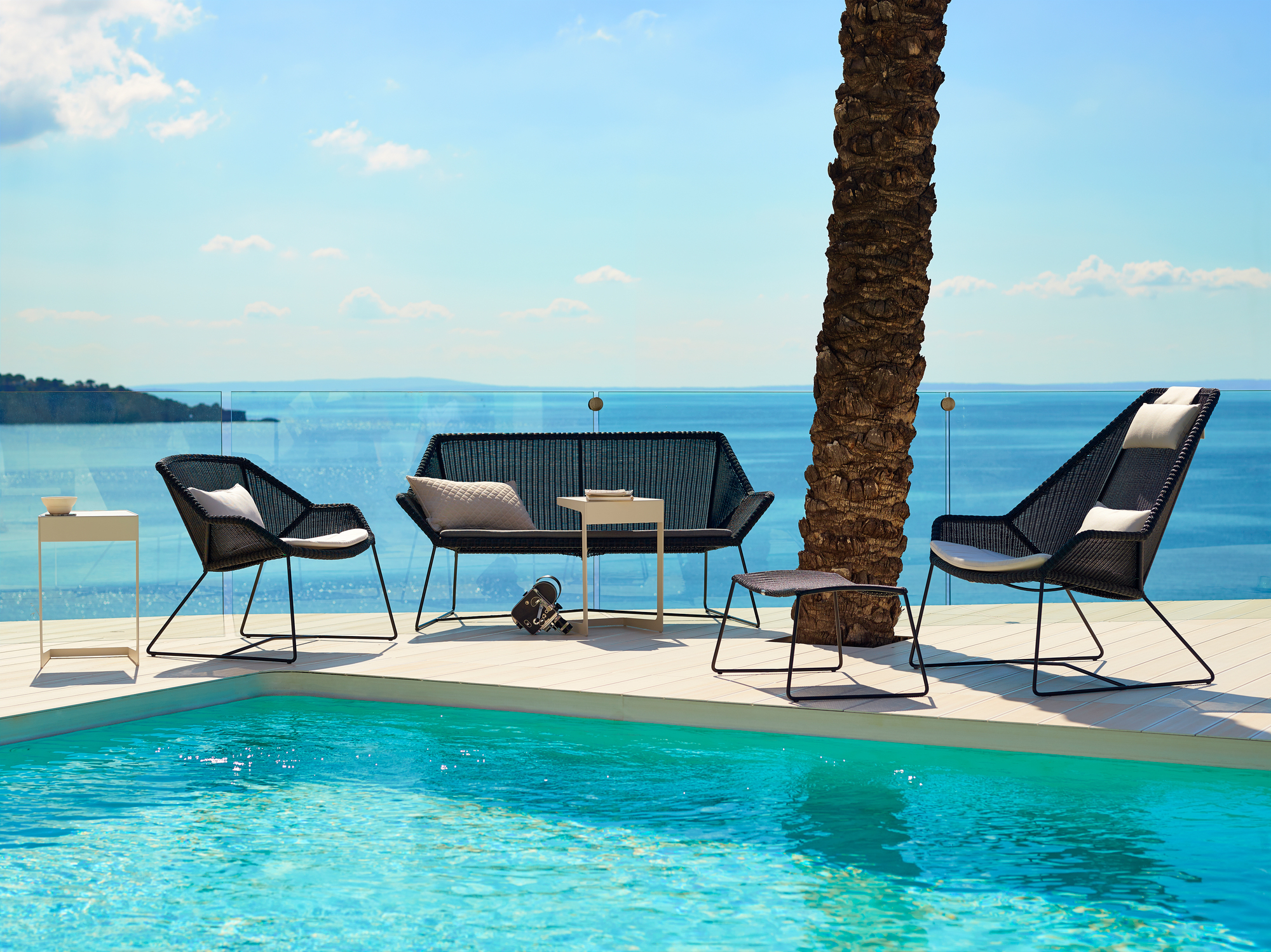 Breeze Outdoor Loungesessel von Cane-Line in Schwarz am Pool mit Meerblick. Gartenmöbel aus Rattan.