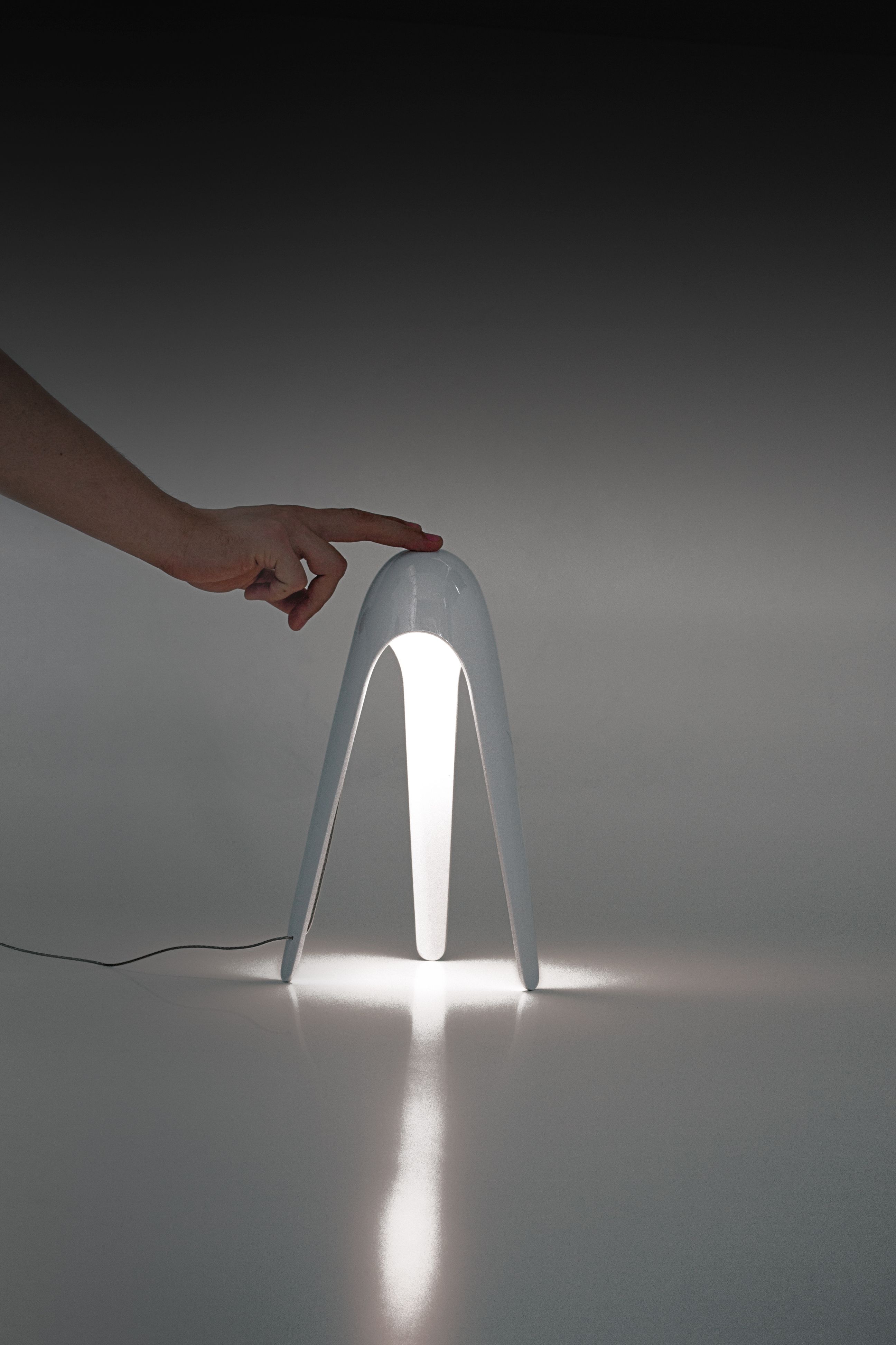 Hellblaue Cyborg Tischleuchte von Martinelli Luce mit Hand, die die Lampe berührt.