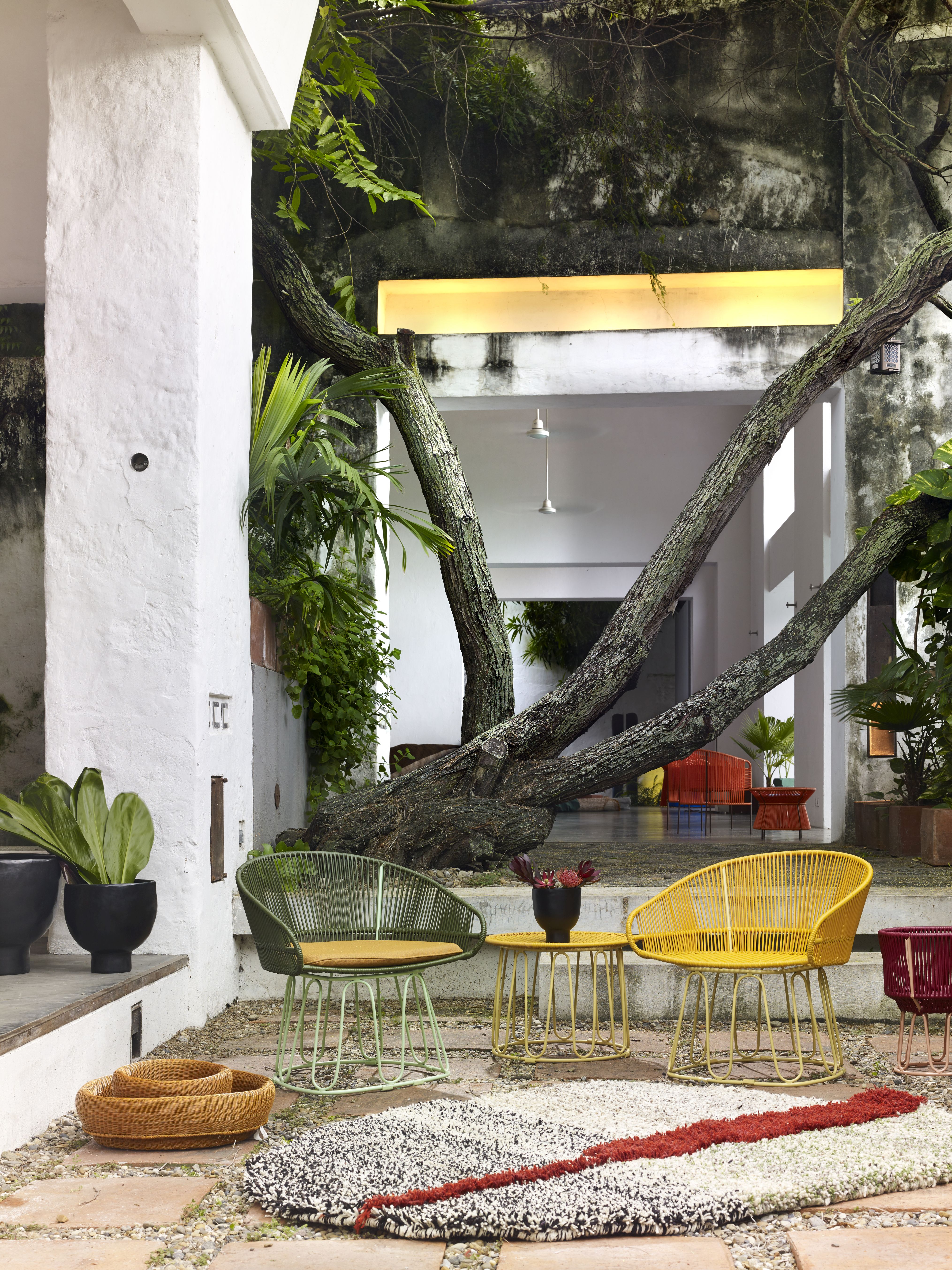 Großer, rechteckiger Nudo Teppich von ames mit abstraktem Muster in einem Außenbereich mit Gartenmöbeln.