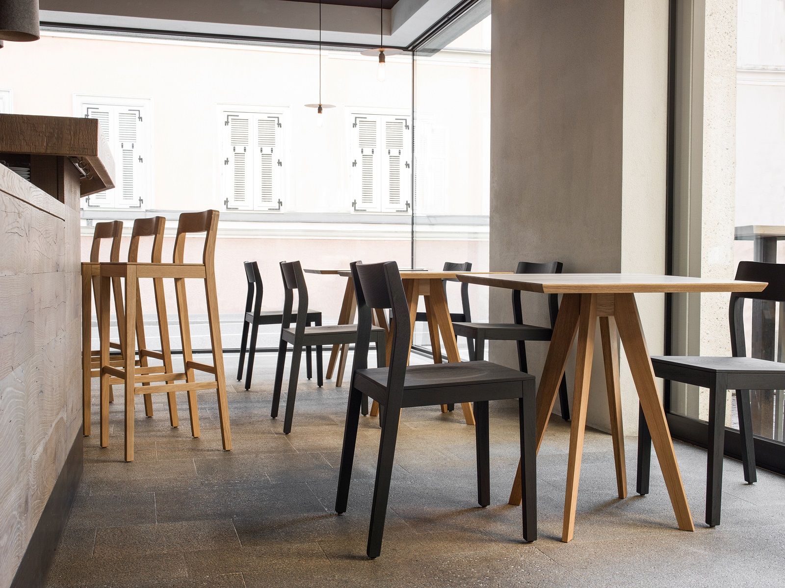 Quadratischer CENA Tisch aus Holz mit Stühlen in einem modernen Restaurant. Esstisch für Esszimmer.