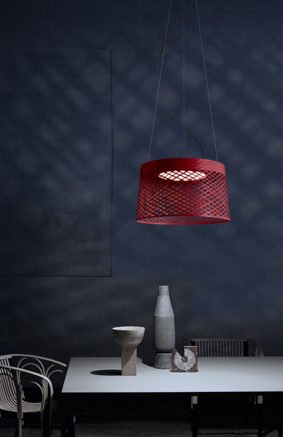 Rote Twiggy Grid Pendelleuchte von Foscarini über Esstisch mit Dekoration und Stuhl.