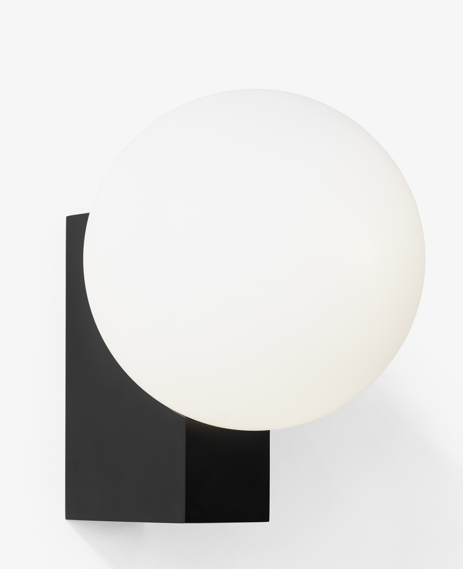 Nahaufnahme der Journey Wandleuchte von AndTradition mit schwarzem Sockel und weißem Glasschirm.