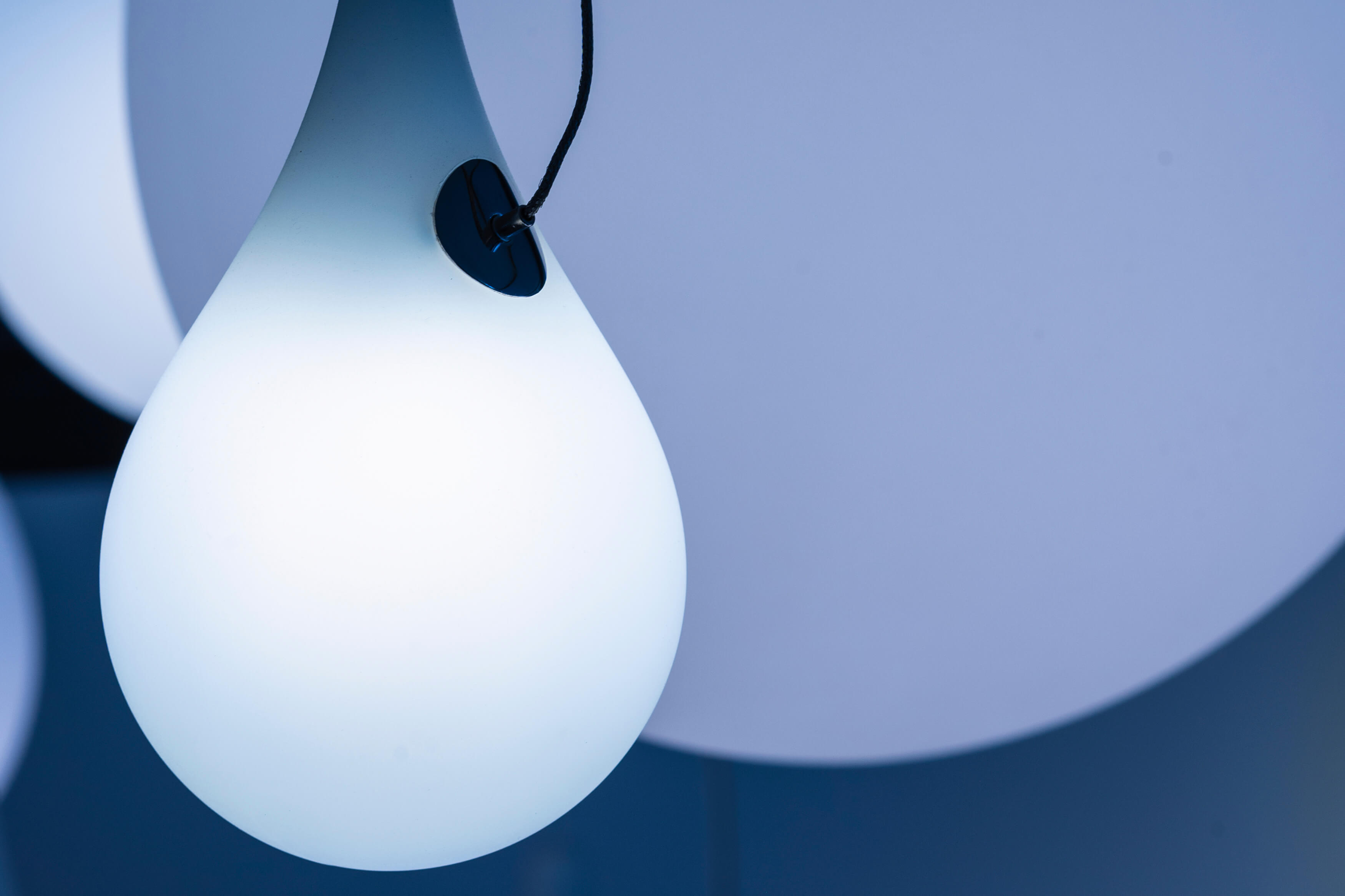 Nahaufnahme der Liquid Light Pendelleuchte von Next, tropfenförmig und leuchtend weiß.