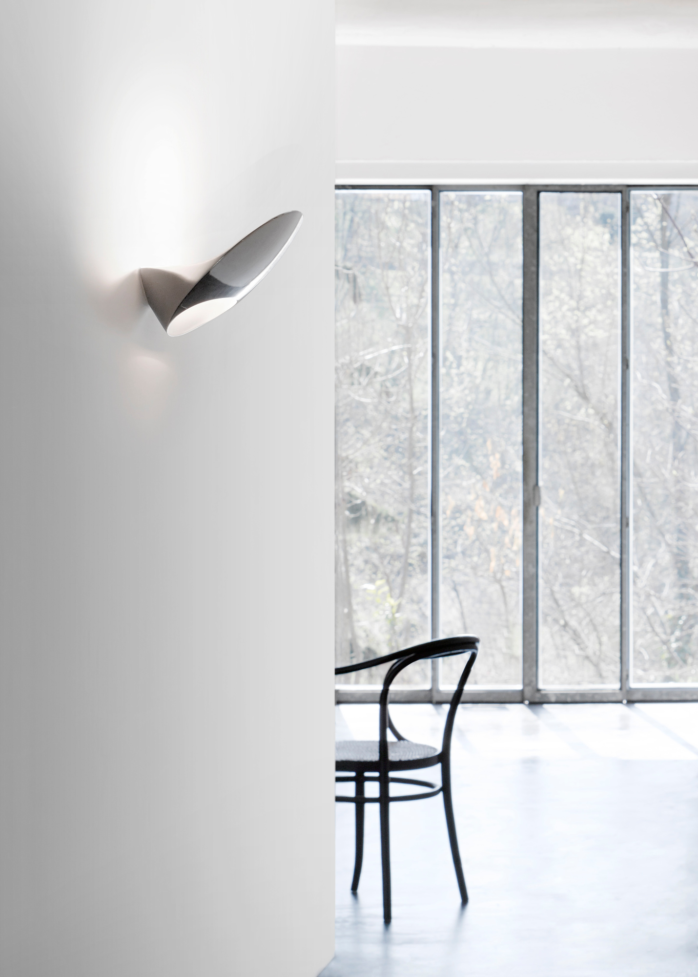 D90 Garbi Wandleuchte von Luceplan, modernes Design, indirekte Beleuchtung, silberfarben, an weißer Wand montiert.