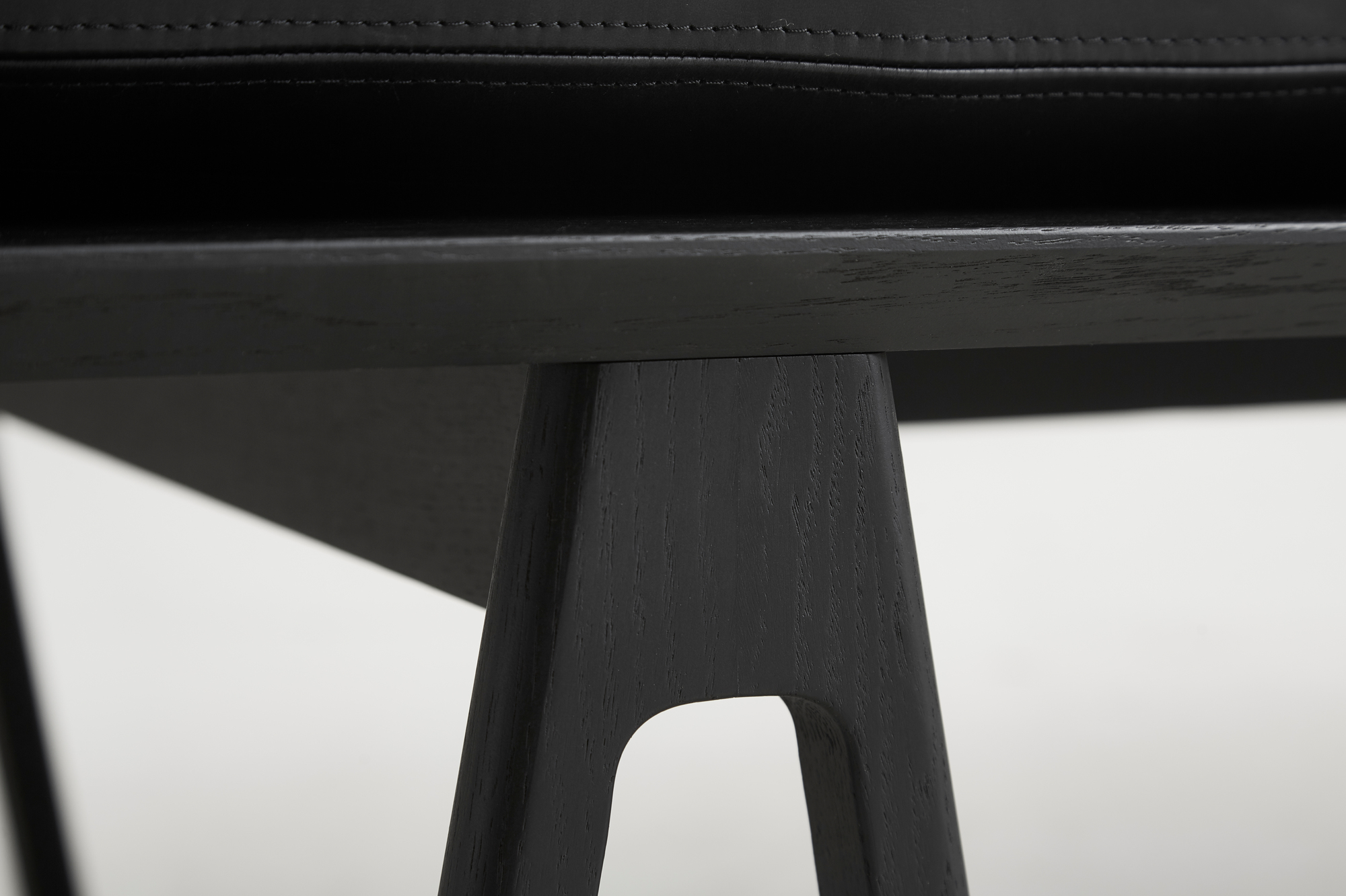 Detailaufnahme der schwarzen Holzbeine der Level Daybed Liege von Woud.