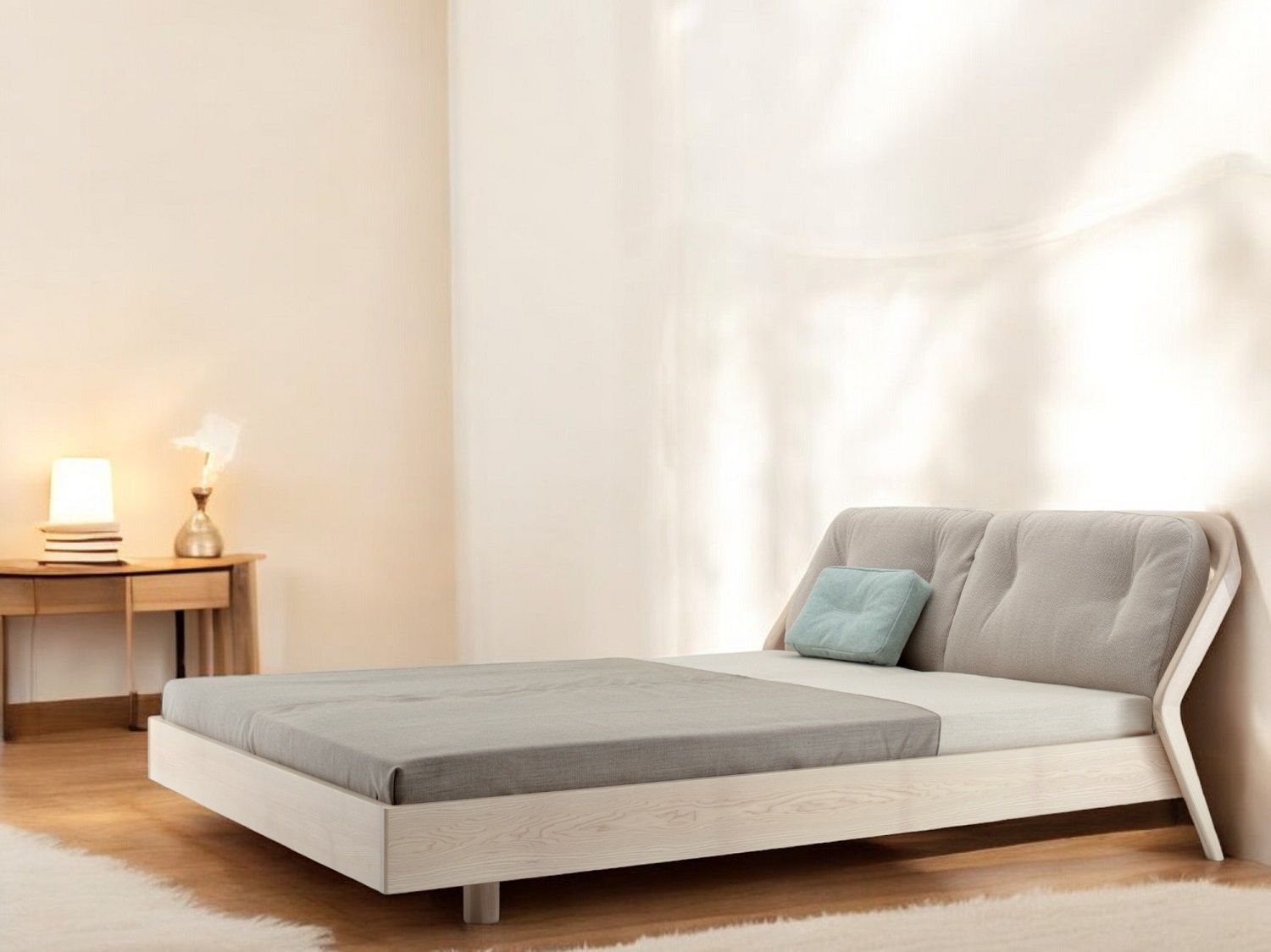 Friday Night Bett: Modernes Massivholzbett mit grauem Bezug und hellblauem Kissen.