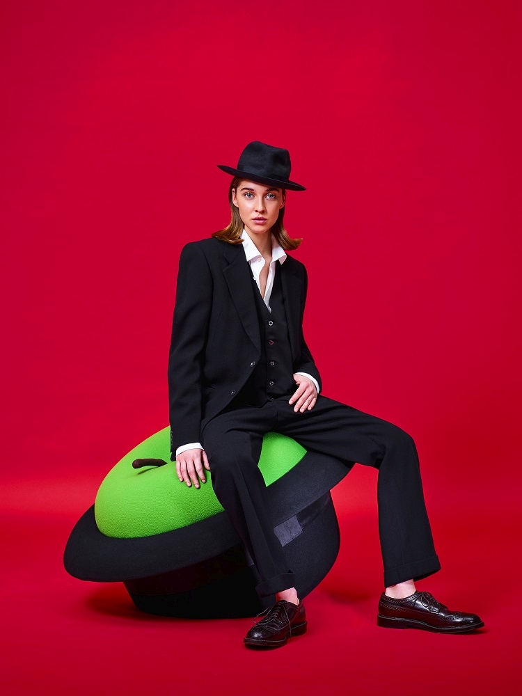 Frau sitzt auf grünem MagriTTA Sculpture-Sessel Pouf von Gufram. Designermöbel für Wohnzimmer und Büro.