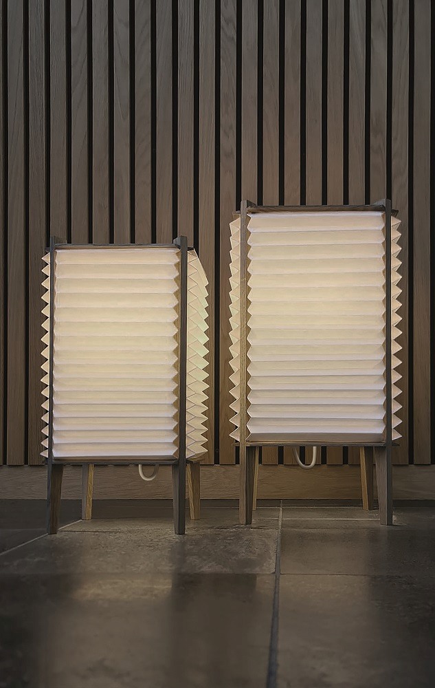 Zwei BEE HIVE Tischleuchten von Le Klint mit plissiertem Lampenschirm und Holzgestell.