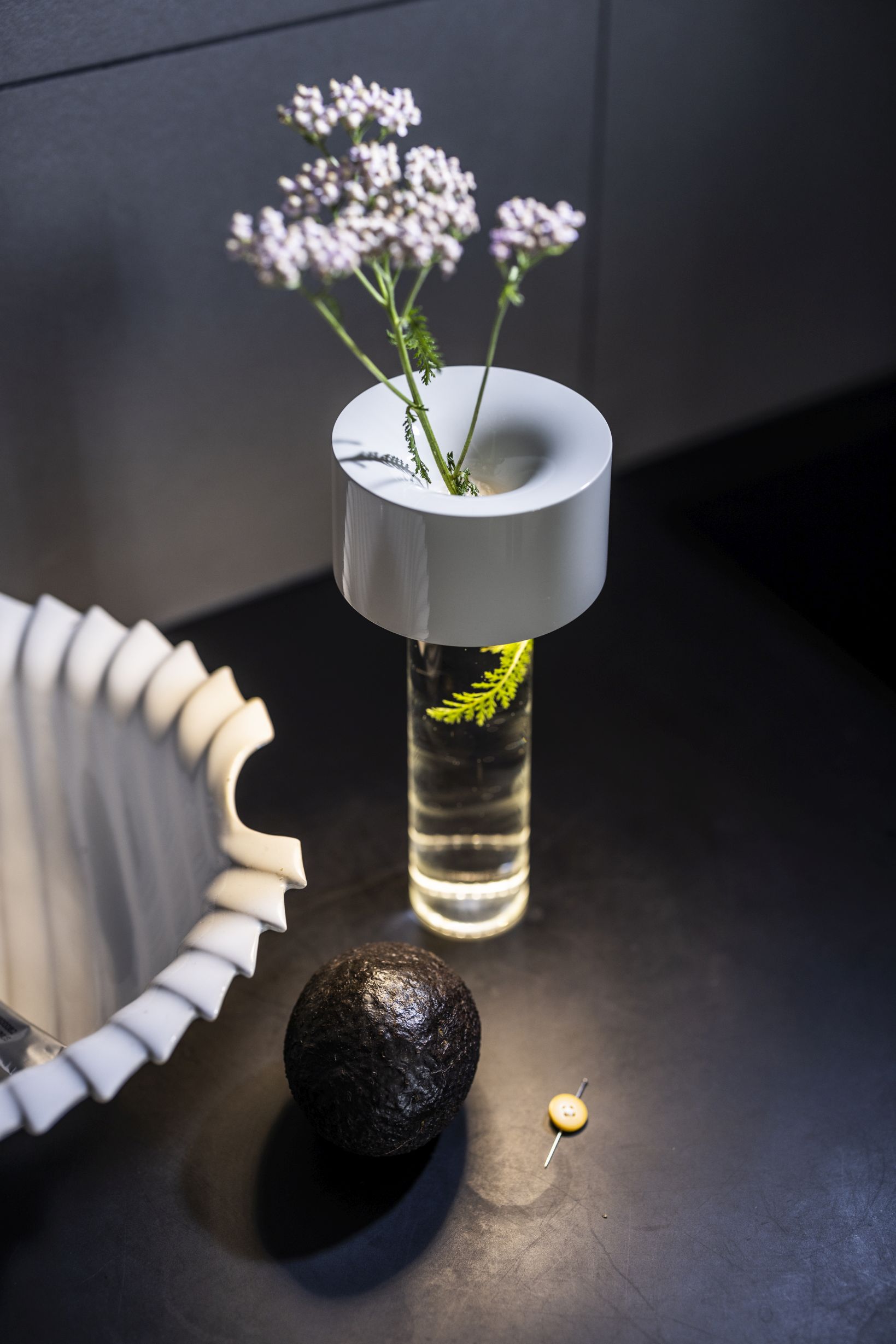 Detailaufnahme der modernen Tischleuchte von Foscarini mit Blumen in einem Glasgefäß.