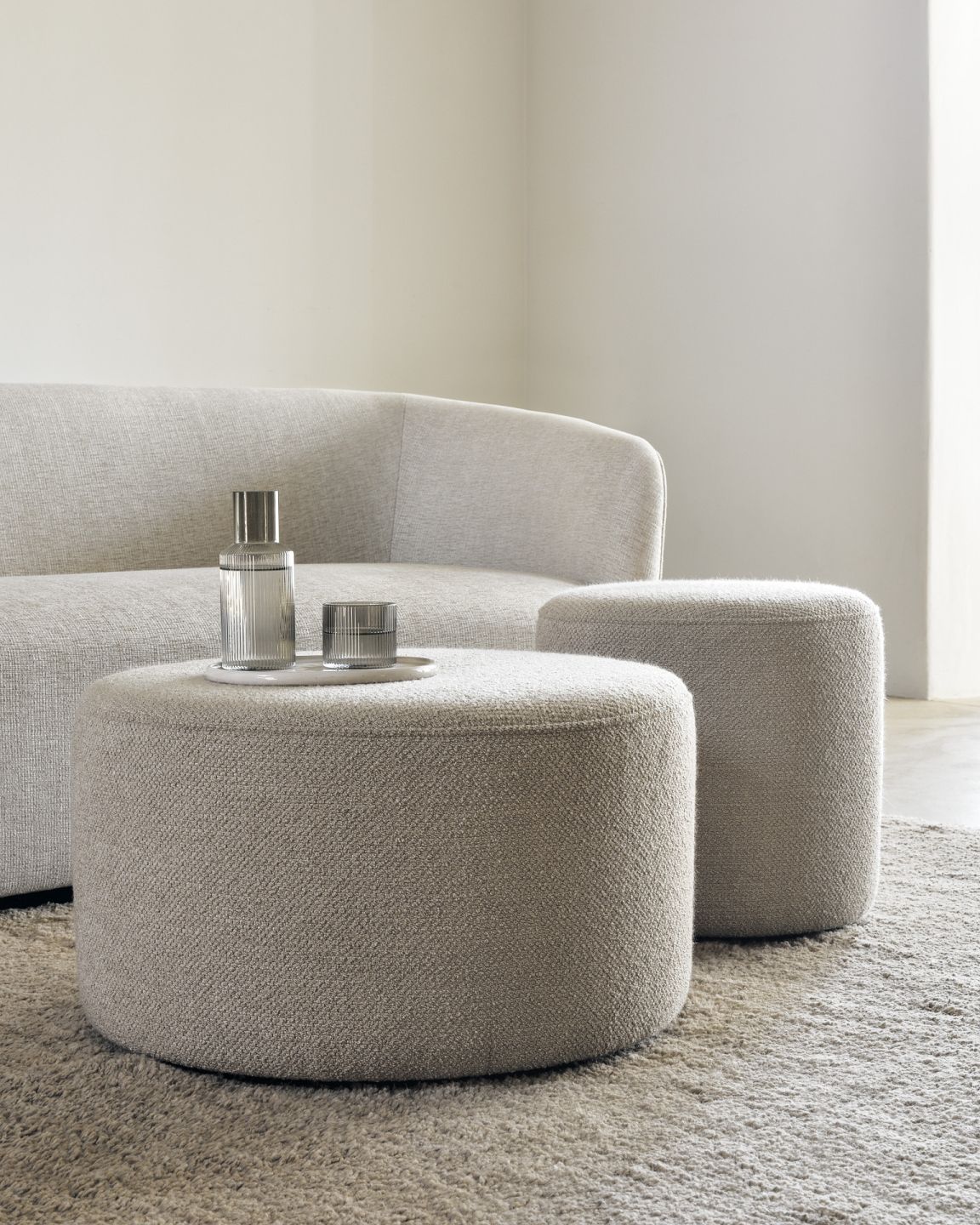 Barrow Sitzhocker von Ethnicraft: Zwei runde, beige Hocker im Wohnzimmer, ideal als Fußhocker oder Beistelltisch.