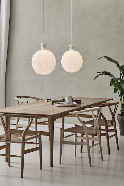 Zwei Model 101 Pendelleuchten von Le Klint mit Papierschirm über einem Esstisch.