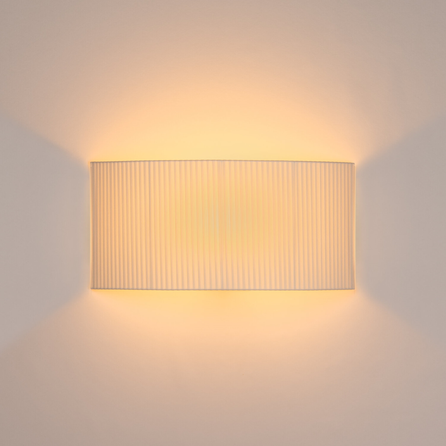 Nahaufnahme der leuchtenden, rechteckigen Santa & Cole Wandleuchte Comodín mit plissiertem Schirm.