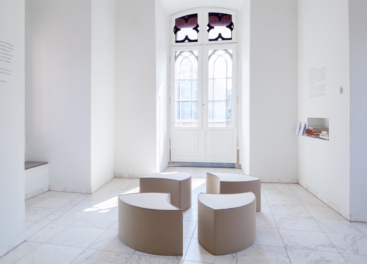 Posito Sitzmöbel von Hey Sign: Vier graue, halbkreisförmige Filzhocker in einem hellen Raum. Sitzmöbel für Wohnen und Büro.