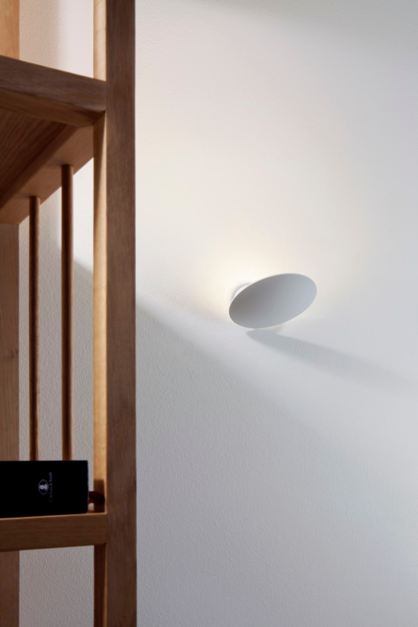 Weiße Lederam WF Wandleuchte von Catellani & Smith an einer weißen Wand, modernes Design.