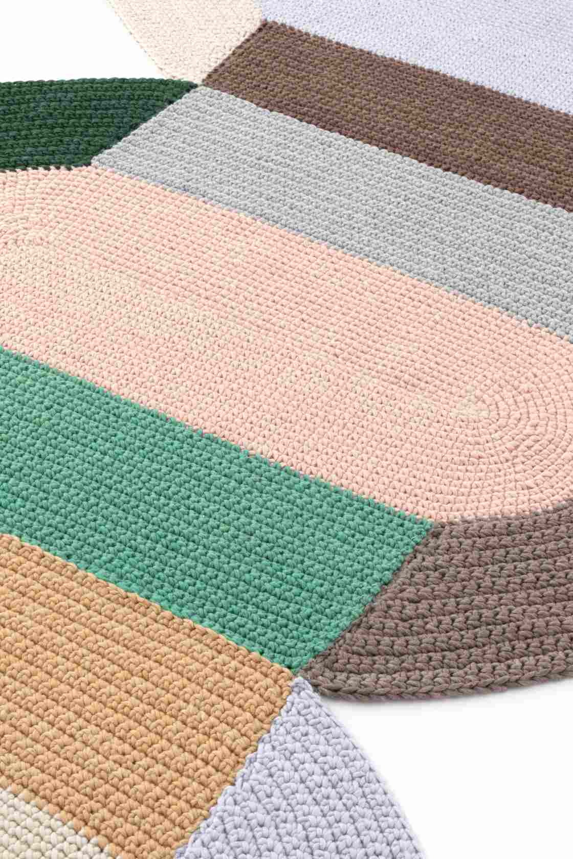 Detailaufnahme des gehäkelten The Crochet Collection Teppichs in verschiedenen Farben und Texturen.