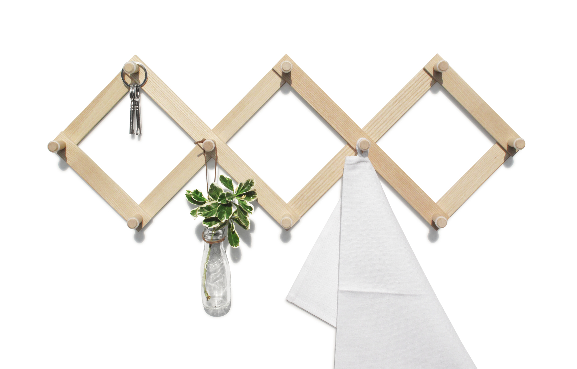 Helle Holz Wandgarderobe Lia Side by Side mit Schlüssel, Pflanze und Handtuch an weißer Wand.