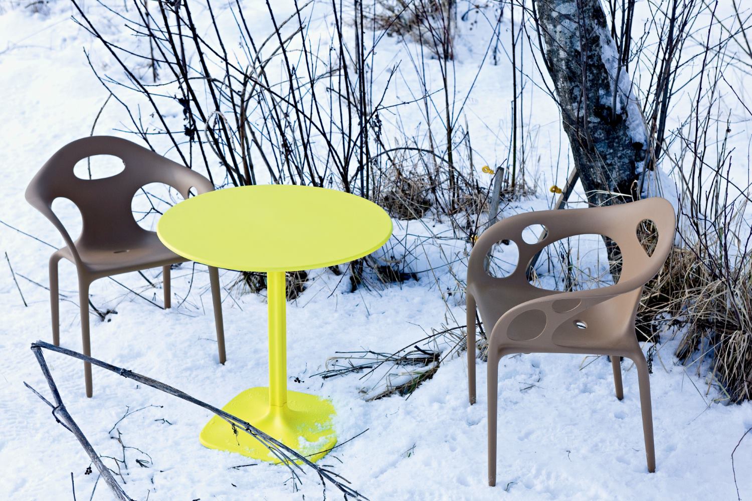 Gelber Supernatural Tisch von Moroso mit zwei Stühlen im Schnee, modernes Outdoor-Möbeldesign.