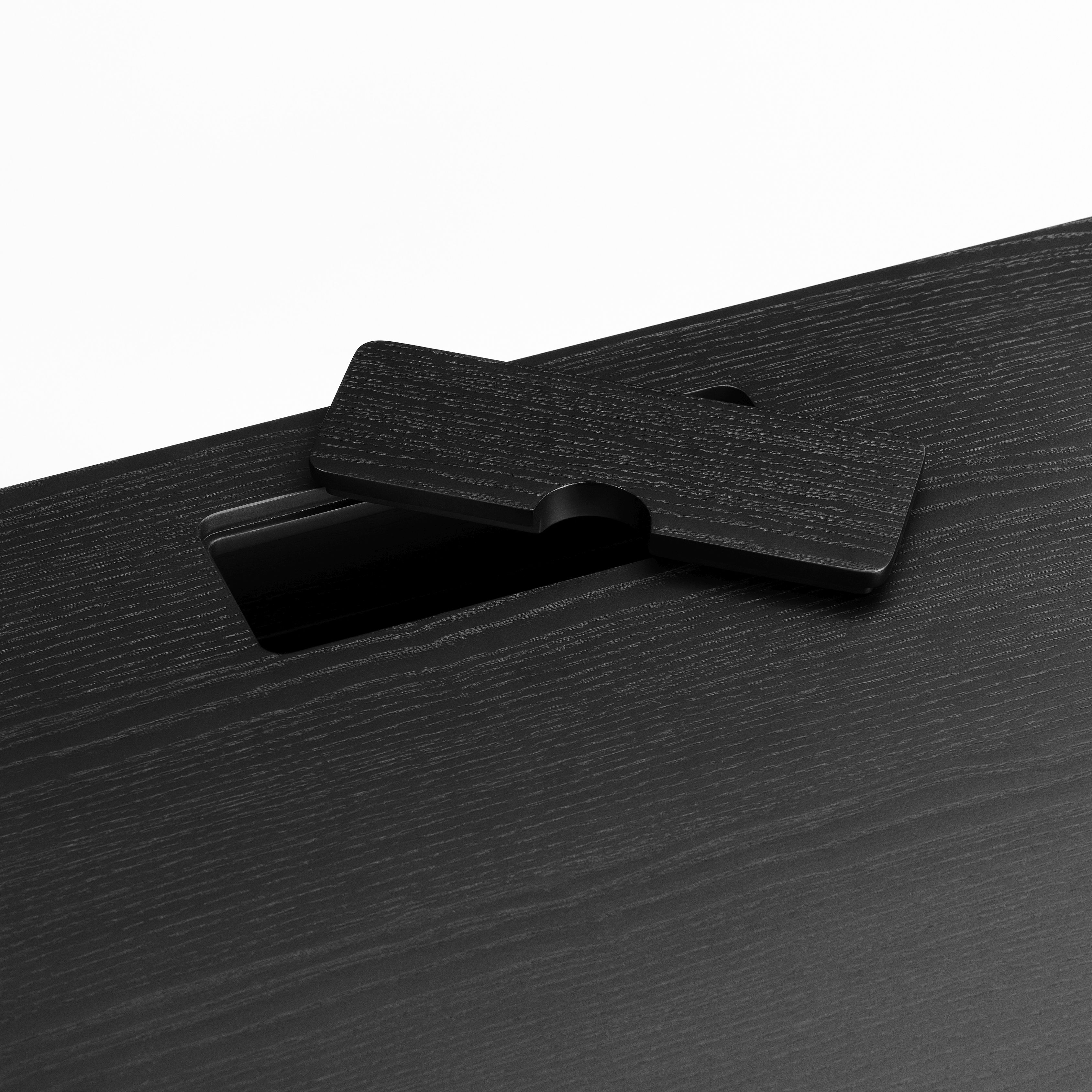Detailaufnahme: Schwarzer JFK Schreibtisch von Norr11 mit Kabeldurchlass für modernes Bürodesign.